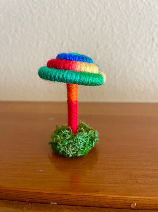 red green blue mushroom collectible Made with bright multicolored yarn wrapped around rope and shaped into a mushroom with small moss covered platform for standing, perfect for mushroom lovers and or collectors, can also be used as an ornament (hook is included in order)  Materials: acrylic yarn, rope, hot glue