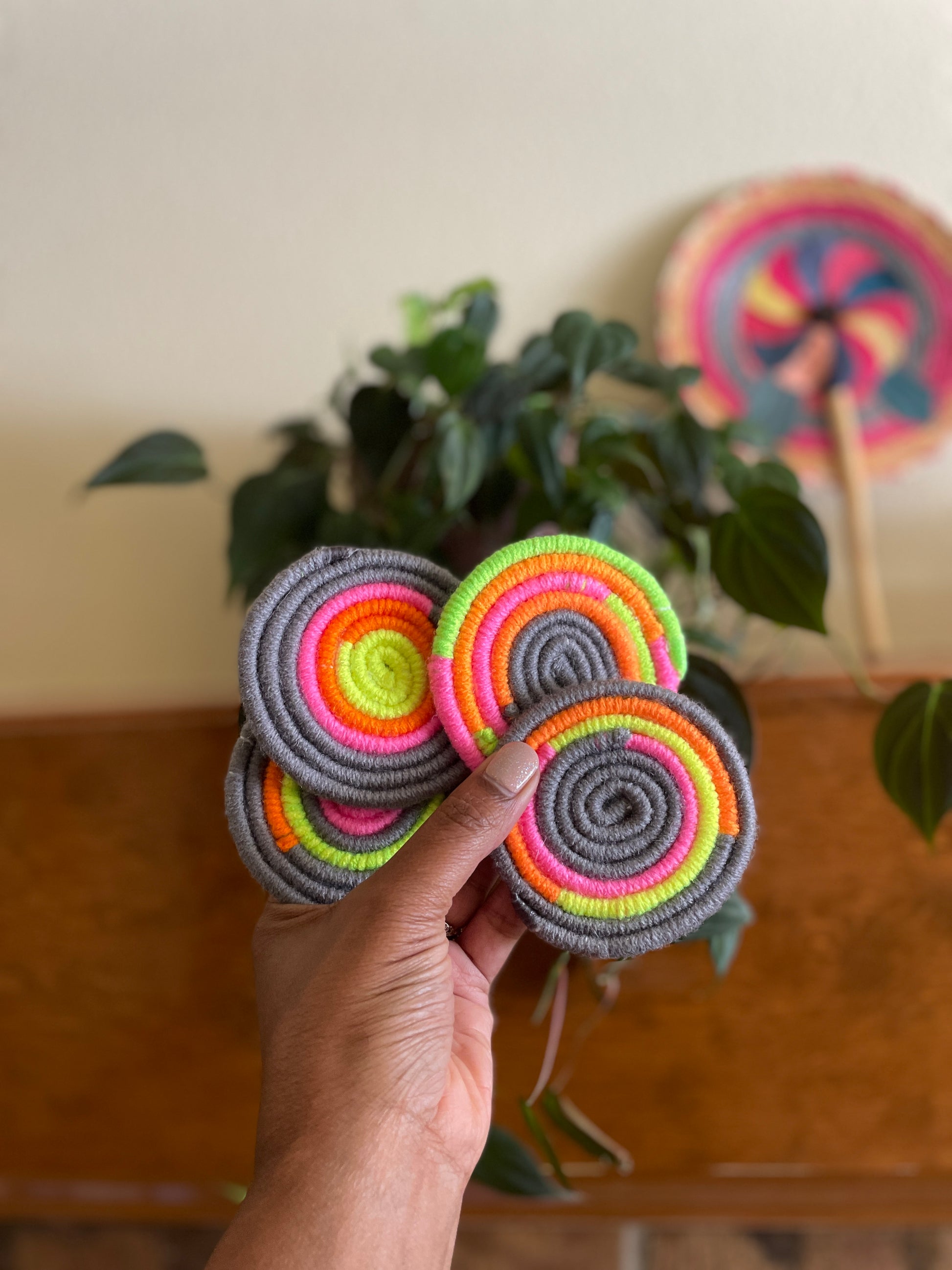 Neon and gray coaster set Comes in neon pink, orange green and gray colors, rope is wrapped in yarn. No 2 pieces are alike, unique pattern and color placement is different on each piece, comes in sets of 4   Materials: Yarn, rope, hot glue