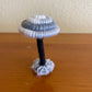 Made with gray black and white yarn wrapped around rope and shaped into a mushroom with small flat platform for standing, perfect for mushroom lovers and or collectors, can also be used as an ornament (hook is included in order)