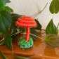 Orange mushroom collectible Made with orange yarn wrapped around rope and shaped into a mushroom with small flat platform adorned with moss for standing, perfect for mushroom lovers and or collectors, can also be used as an ornament (hook is included in order)  Materials: acrylic yarn, rope, hot glue  Dimensions:
