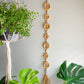 raffia and shells garland Vertical garland made with raffia wrapped around wood circles and embellished with shells on raffia braid with tassel on the bottom  Dimensions: 34 inches long, 2 inches wide  Materials: Raffia, wood circles, shells, hot glue   